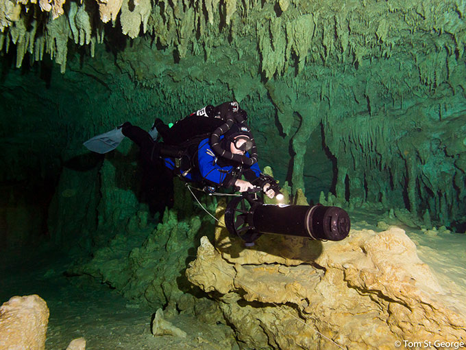 Photo of diver in cave with scooter